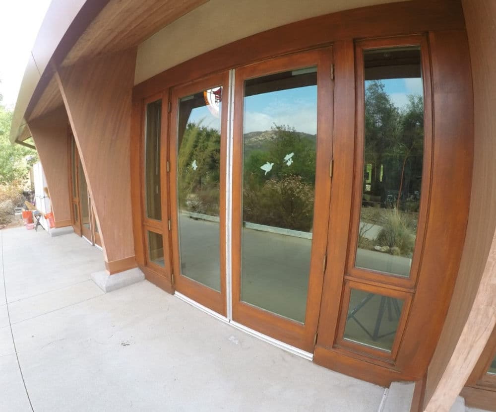 Modern wooden double doors with large glass panels, set in a contemporary architecture style.